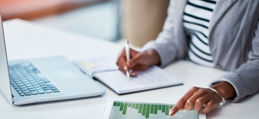 Shot of an unrecognizable businesswoman using a digital tablet with graphs on it in a modern office