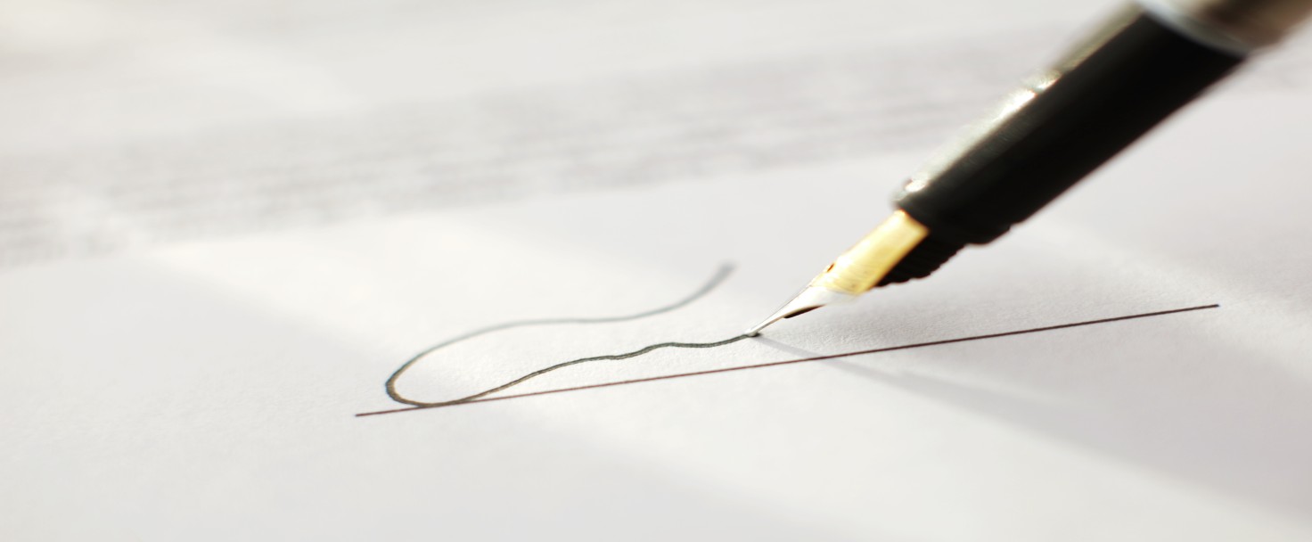 Close up of signing contract with signature.