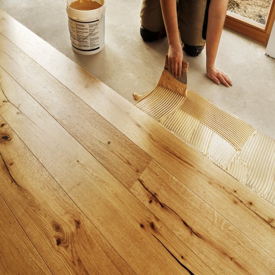 Man laying finished oak parquet flooring, close-up