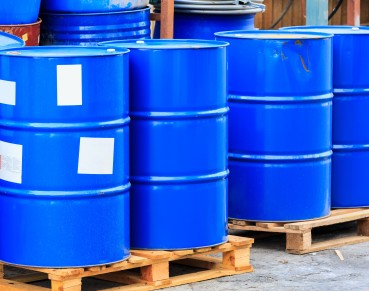 Many blue barrels standing on wooden pallets on a chemical plant