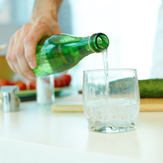 Man pouring mineral water in glass