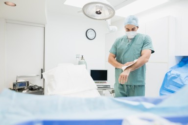 Plastic surgeon drying hands in operating room
