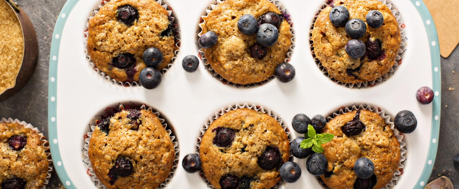 Healthy vegan banana blueberry muffins with fresh berries overhead shot