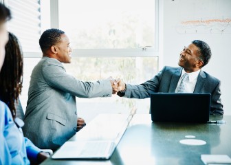 Businessmen shaking hands during meeting in office conference room