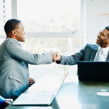 Businessmen shaking hands during meeting in office conference room