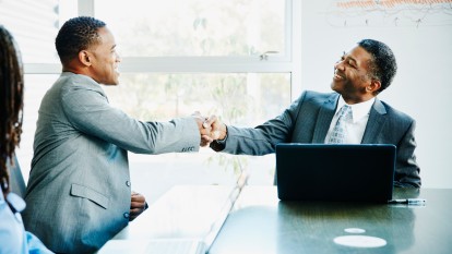 Businessmen shaking hands during meeting in office conference room