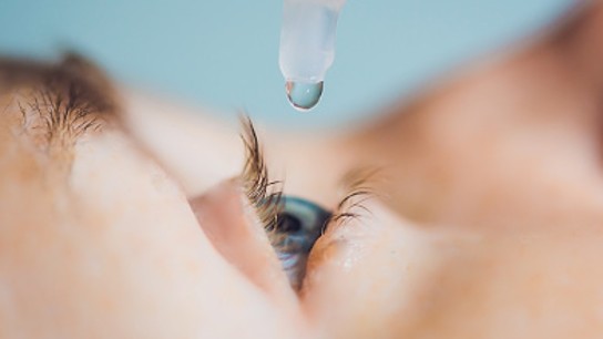 Closeup of eyedropper putting liquid into open eye