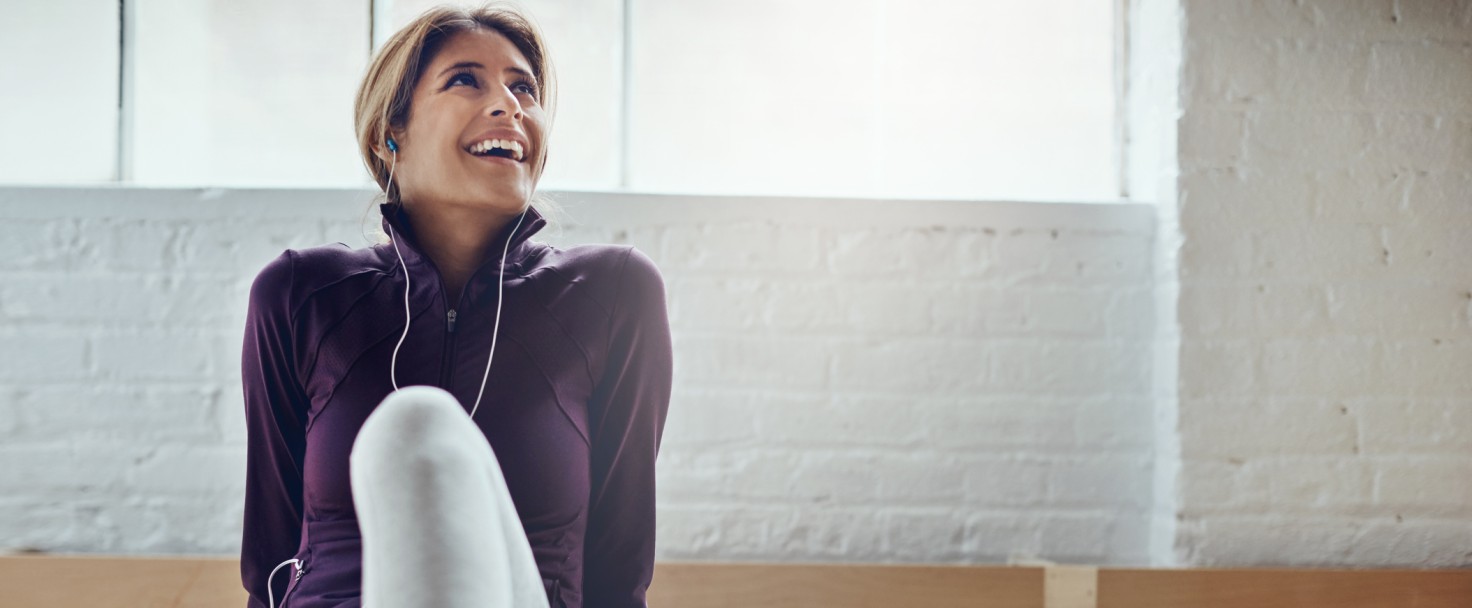 Shot of an attractive young woman listening to music while working out at home
