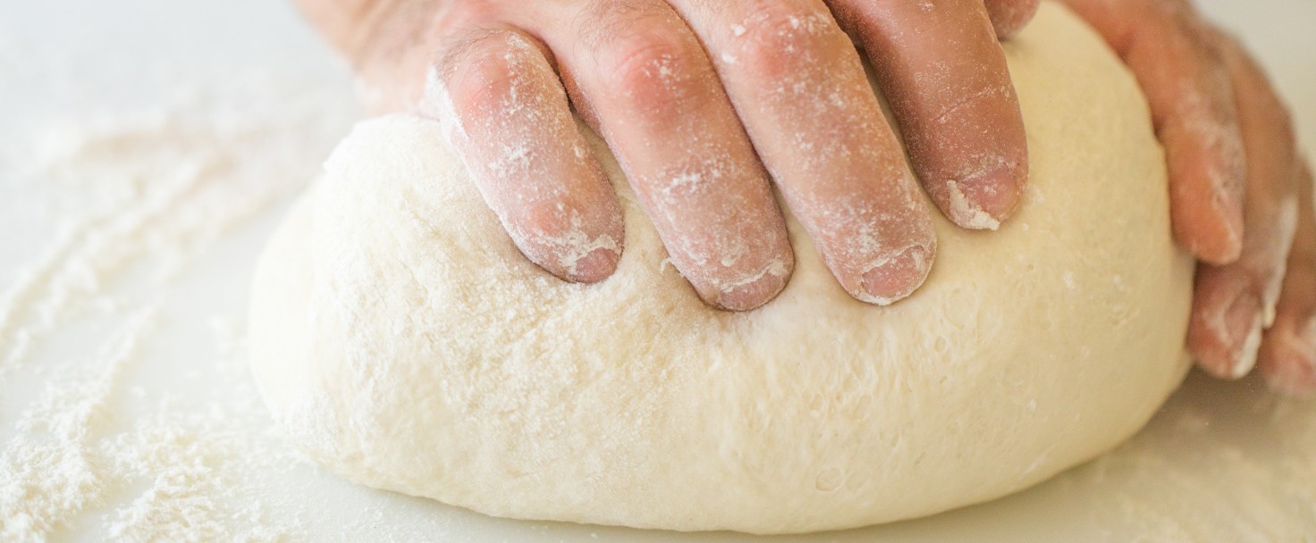 Cropped Hands Kneading Dough On Kitchen Counter