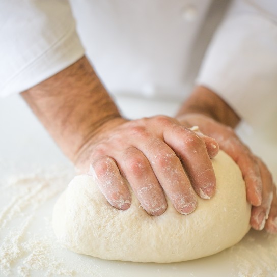 Cropped Hands Kneading Dough On Kitchen Counter