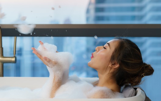 Asian woman takes a bath with soap bubble in bathtub at bathroom of luxury hotel in downtown city while on vacation.
GettyImages-1305264054.jpg