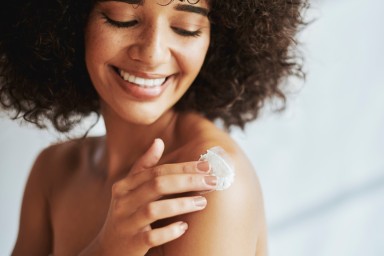 Black woman, cream and skin with smile, shoulders and self care, start and morning in home. Woman, product and skin for cosmetics, healthy glow and natural aesthetic for self love, health or beauty
GettyImages-1460122296.jpg