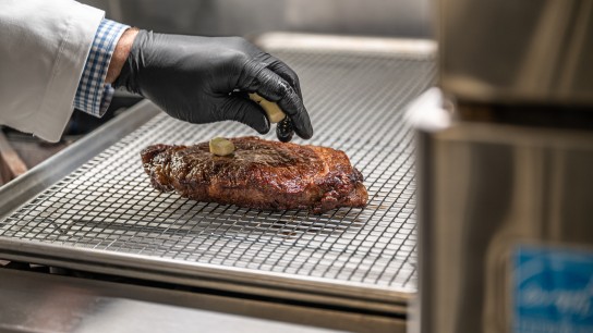 Placing butter on the steak on the grill in the application kitchen, Allentown, USA