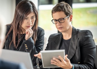 Business women discussing topic while looking at the tablet, Essen, Germany