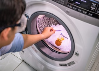 Brenntag HI & I expert placing the test detergent into the washing machine, Ho Chi Minh, Vietnam