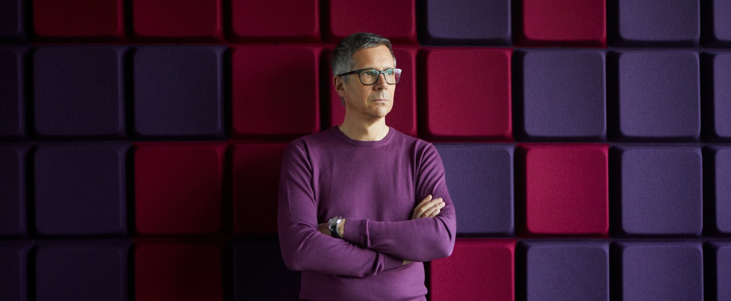 Businessman standing at a noise reduction wall in office