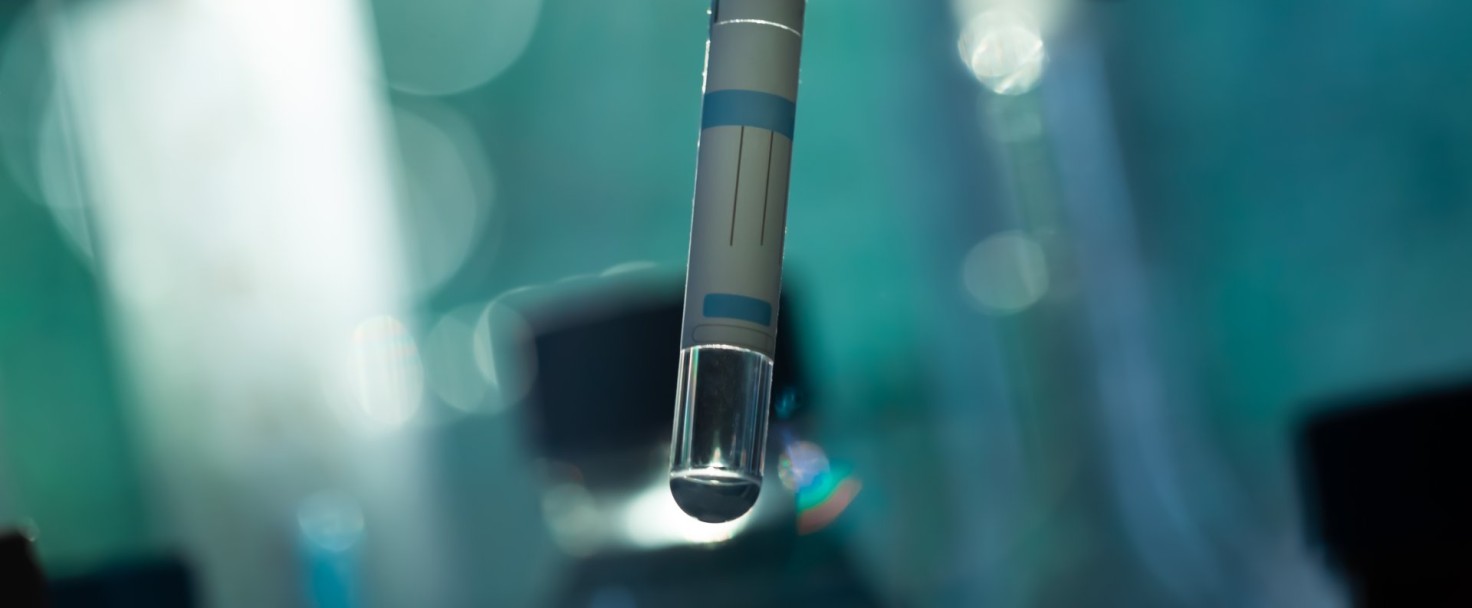 A scientist's hand holds a test tube with a substance on dark
GettyImages-2181382538.jpg