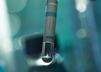 A scientist's hand holds a test tube with a substance on dark
GettyImages-2181382538.jpg