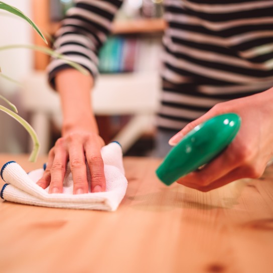 Close-up of woman hands cleaning the surface of a table with disinfectant spray & cloth at home
GettyImages-1216335746.jpg