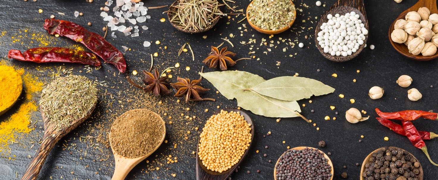 Close-Up Of Various Spices In Wooden Spoons On Table
