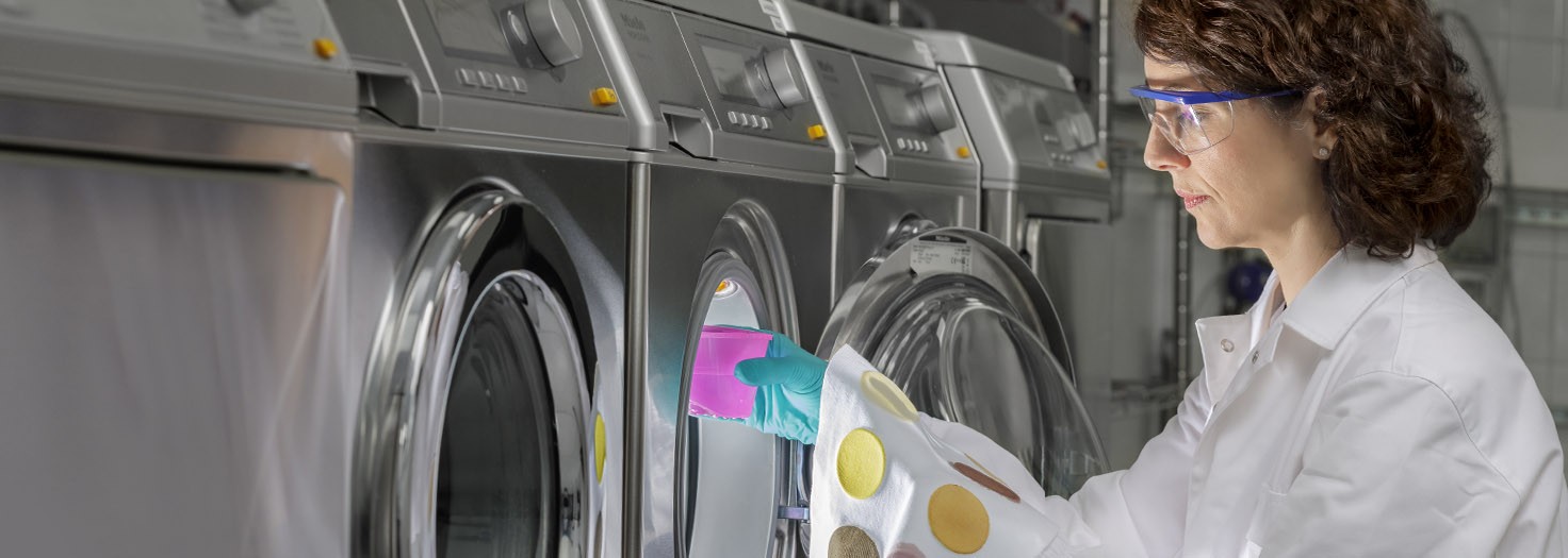 Woman inspecting interior of industrial washing machine