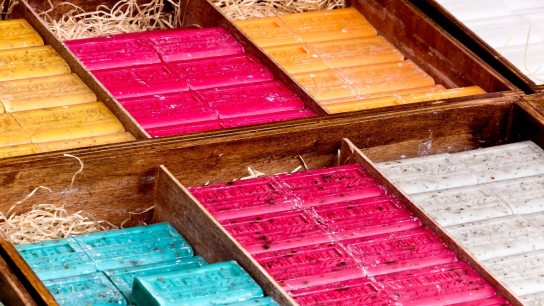 Bars of Marseille soap in multiple vibrant colors are on display on a market stable in summer in L'Isle-sur-la-Sorgue, France