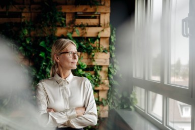 Businesswoman in green office looking out of window