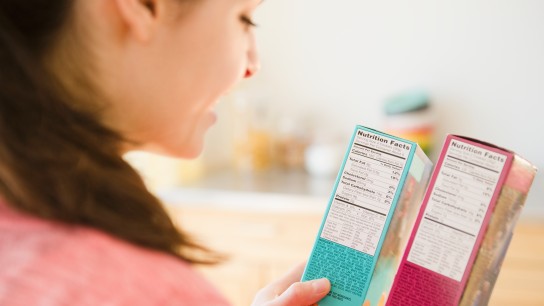 Woman reading nutrition facts on food packaging