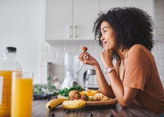 Shot of a young woman making a healthy snack with fruit at home