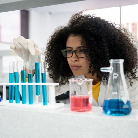 Portrait of a STEM female student in class at the lab looking at some test tubes â education concepts