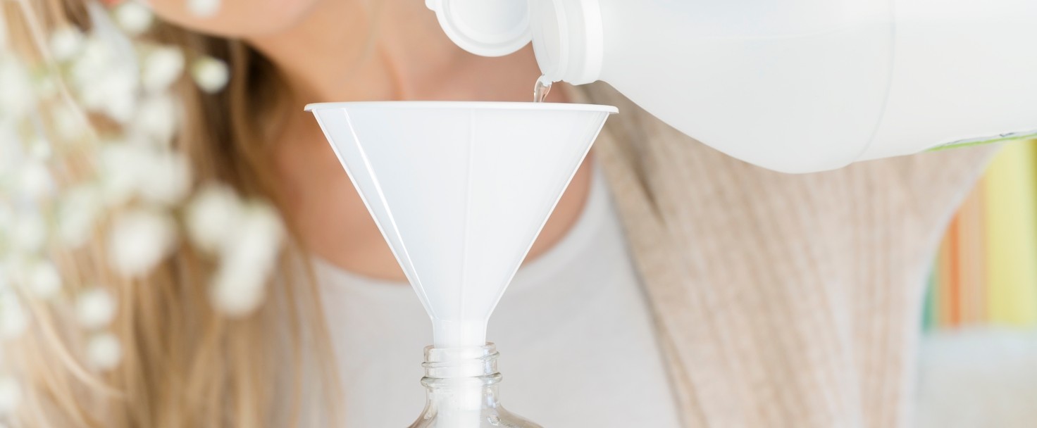 Woman upcyling a plastic bottle with thyme, citrus water
