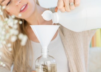 Woman upcyling a plastic bottle with thyme, citrus water