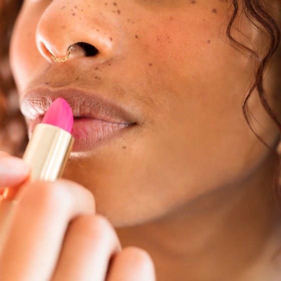 Woman applying lip stick