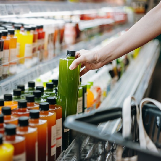 Person grabs a bottle of juice out of the refrigerator