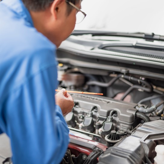 A car mechanic is doing a vehicle maintenance inspection