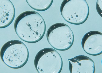 Drops of natural moisturizing gel on blue background. Flat lay, top view. Skincare beauty product