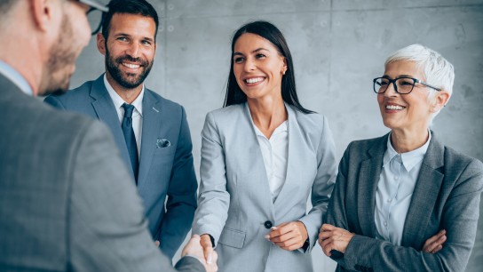 Business people shaking hands in the office. Business persons handshaking during a meeting in modern office.