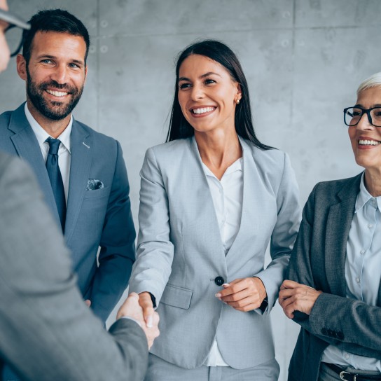 Business people shaking hands in the office. Business persons handshaking during a meeting in modern office.