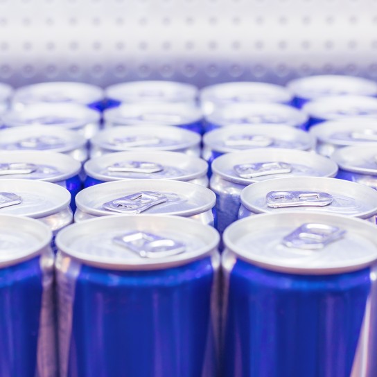 Cans with Energy drink in supermarket. Selective focus.