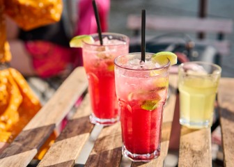 Two glasses watermelon lime lemonade outdoors on a sunny day on a wooden table. Summertime concept. Selective focus.