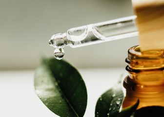 Amber bottle with serum or essential oil. Natural organic cosmetic, aromatherapy message oil. A drop of oil at the end of a pipette