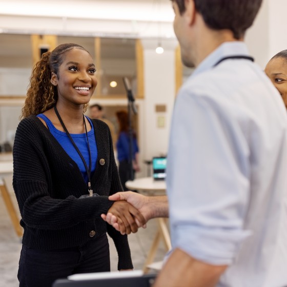 Businesswoman shaking hands with colleagues in office during a conference event. African woman meeting businesspeople at the conference in office.