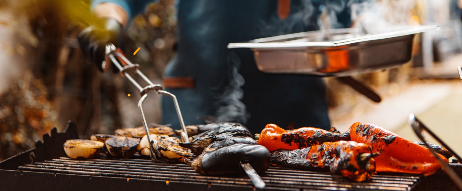 Unknown man preparing BBQ food on an outdoor grill