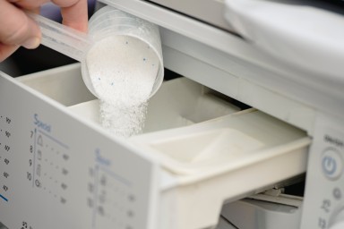 Pouring washing powder in washing machine