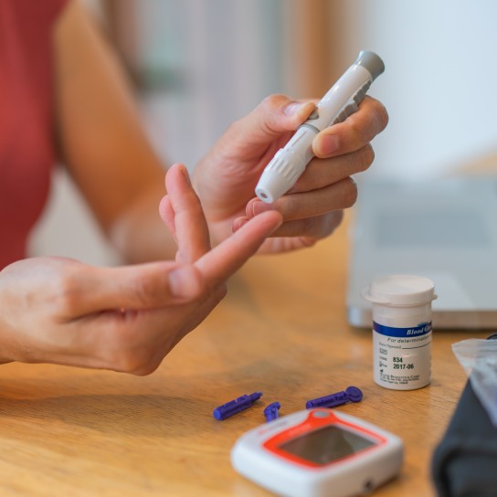 young woman using blood test kit at home while doing health check . home finger prick blood test . close up, diabetes concept, elderly health care,