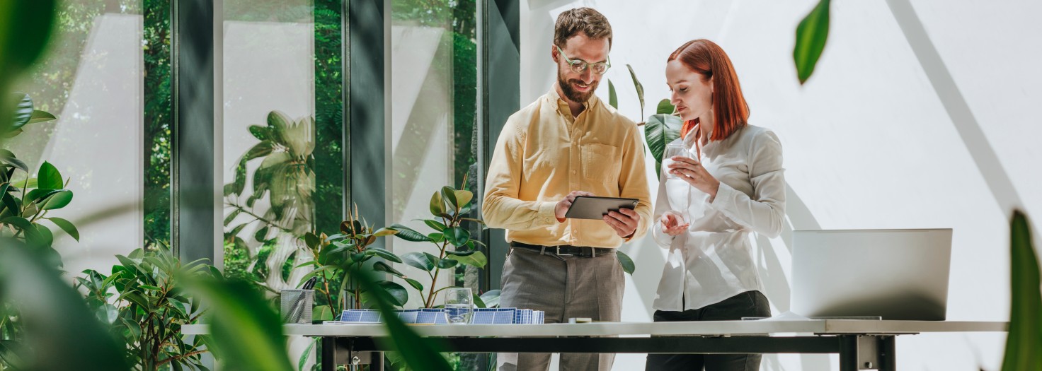 Businesswoman having discussion with colleague using tablet PC in office