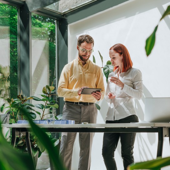 Businesswoman having discussion with colleague using tablet PC in office