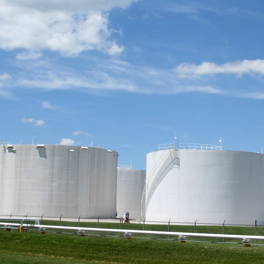 White storage tanks under a blue sky. Gasoline, oil, or other storage.