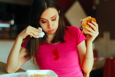 Clumsy restaurant customer dropping some tomato sauce on pink blouse