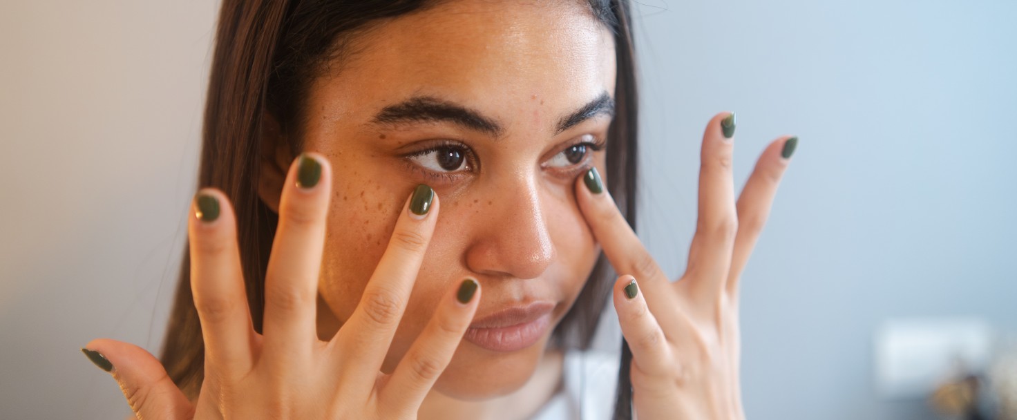 Close-up of a beauty latin young woman applying anti ageing cream to the face